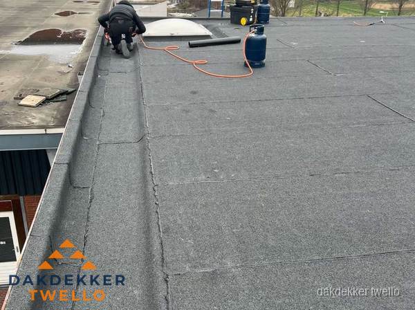 Dakdekker repareert bitumen dakbedekking op groot plat dak in Twello Dakdekker repareert bitumen dakbedekking op groot plat dak in Twello