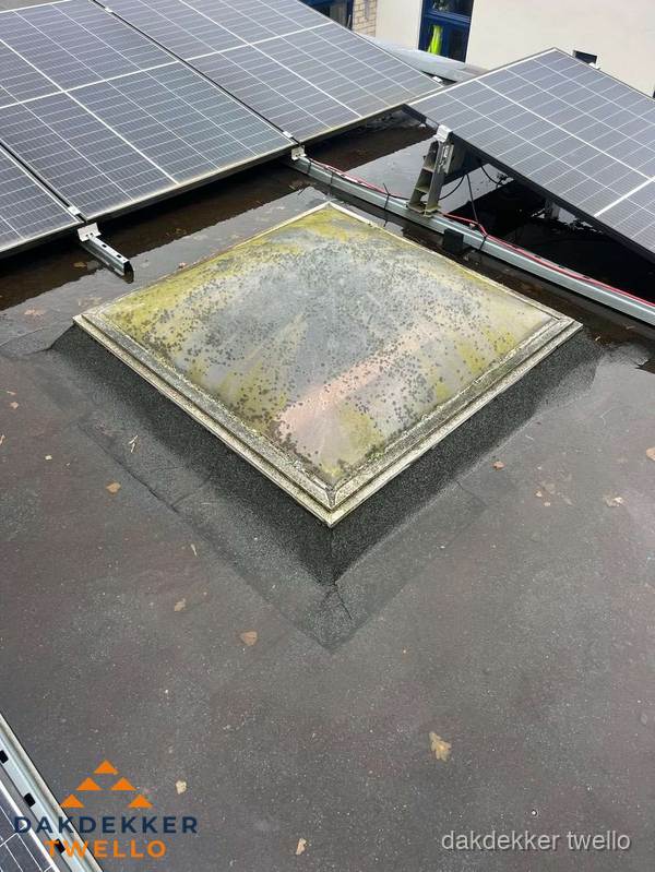Vervuilde lichtkoepel op plat dak met zonnepanelen in Twello Vervuilde lichtkoepel op plat dak met zonnepanelen in Twello