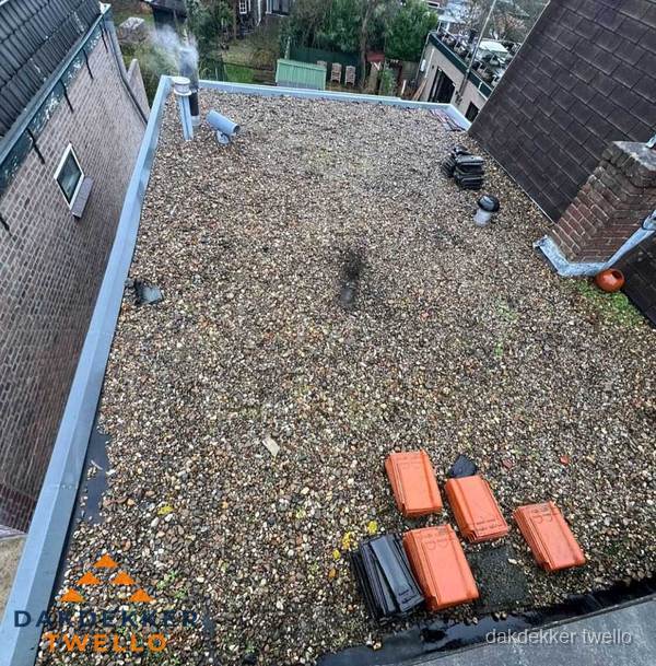 Plat dak met grindballast en dakdoorvoeren in Twello