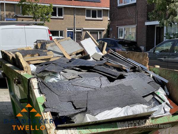 Afvalcontainer met gesloopt dakmateriaal tijdens dakkapel renovatie in Twello Afvalcontainer met gesloopt dakmateriaal tijdens dakkapel renovatie in Twello