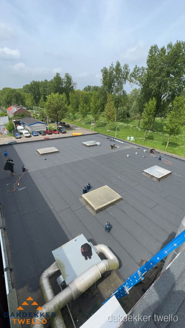 Dakdekker aan het werk op groot plat dak met bitumen in Twello Dakdekker aan het werk op groot plat dak met bitumen in Twello