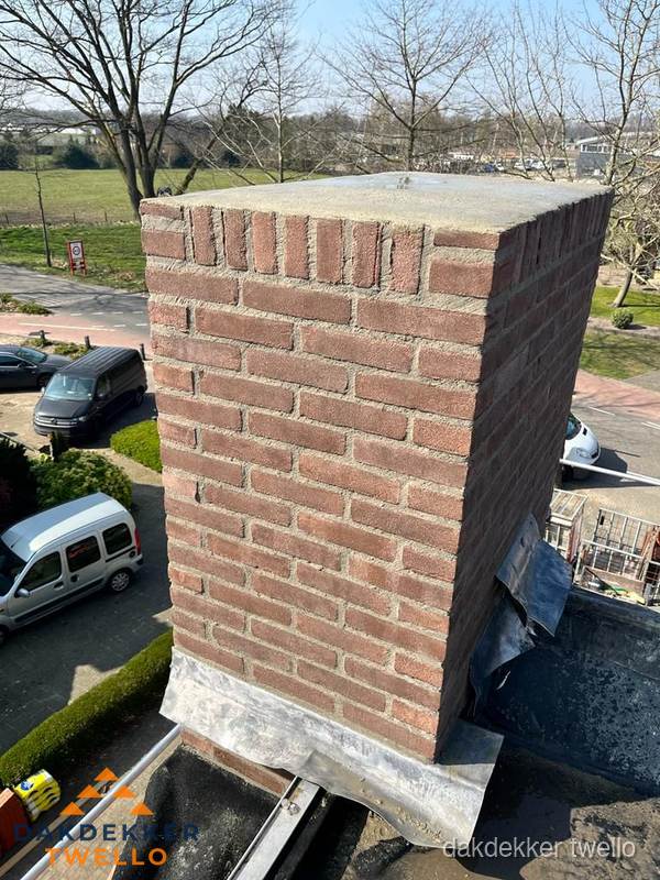 Gemetselde schoorsteen met loodaansluiting op dak in Twello Gemetselde schoorsteen met loodaansluiting op dak in Twello