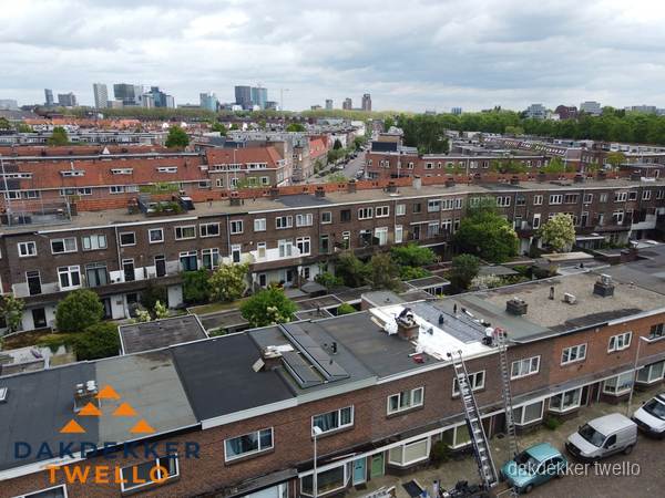 Spoed dakdekker aan het werk op plat dak in woonwijk Twello